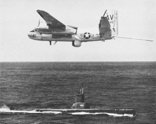 A Grumman S2F-3 Tracker of anti-submarine squadron VS-36 Grey Wolves, with its MAD boom extended, passes over the Tench-class submarine USS Sirago (SS-485) in 1962